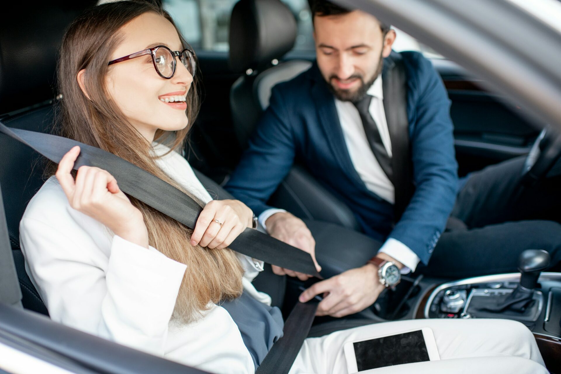 Man fastening the car safe belt to a woman