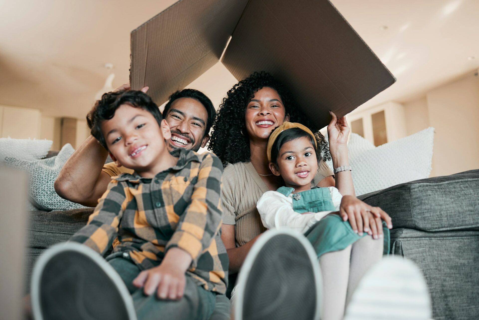 New home, family and portrait with cardboard box for moving, mortgage and property purchase. Living